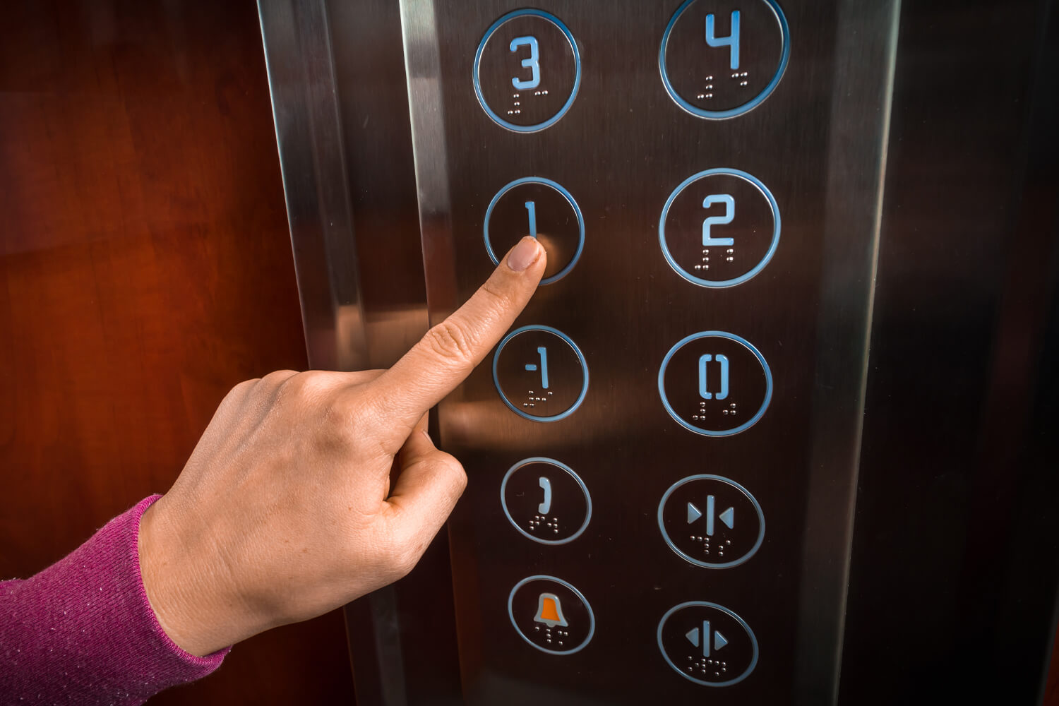 Woman pushing elevator button